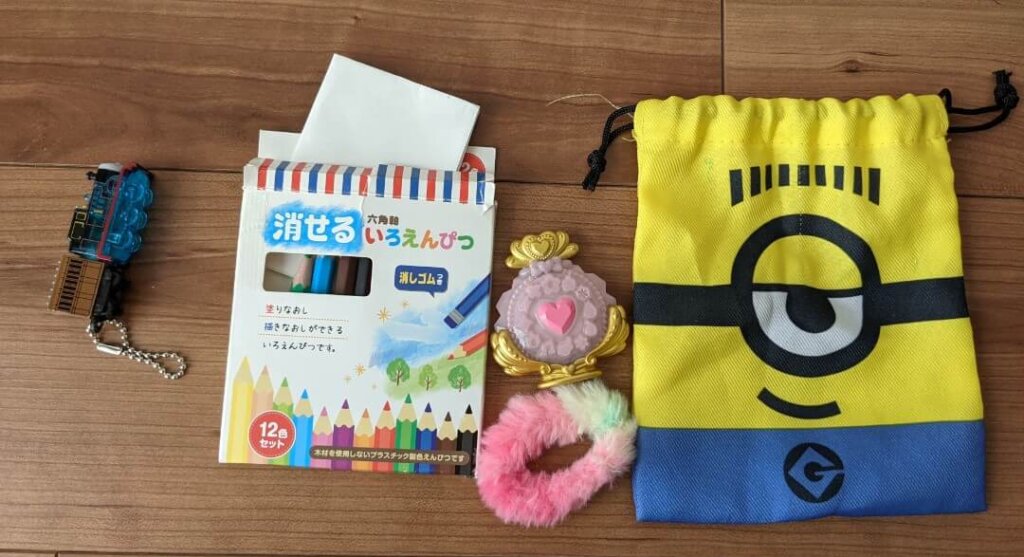 トーマスの光るおもちゃ、色鉛筆、紙を折りたたんだもの、プリキュアのミラー、ヘアゴム